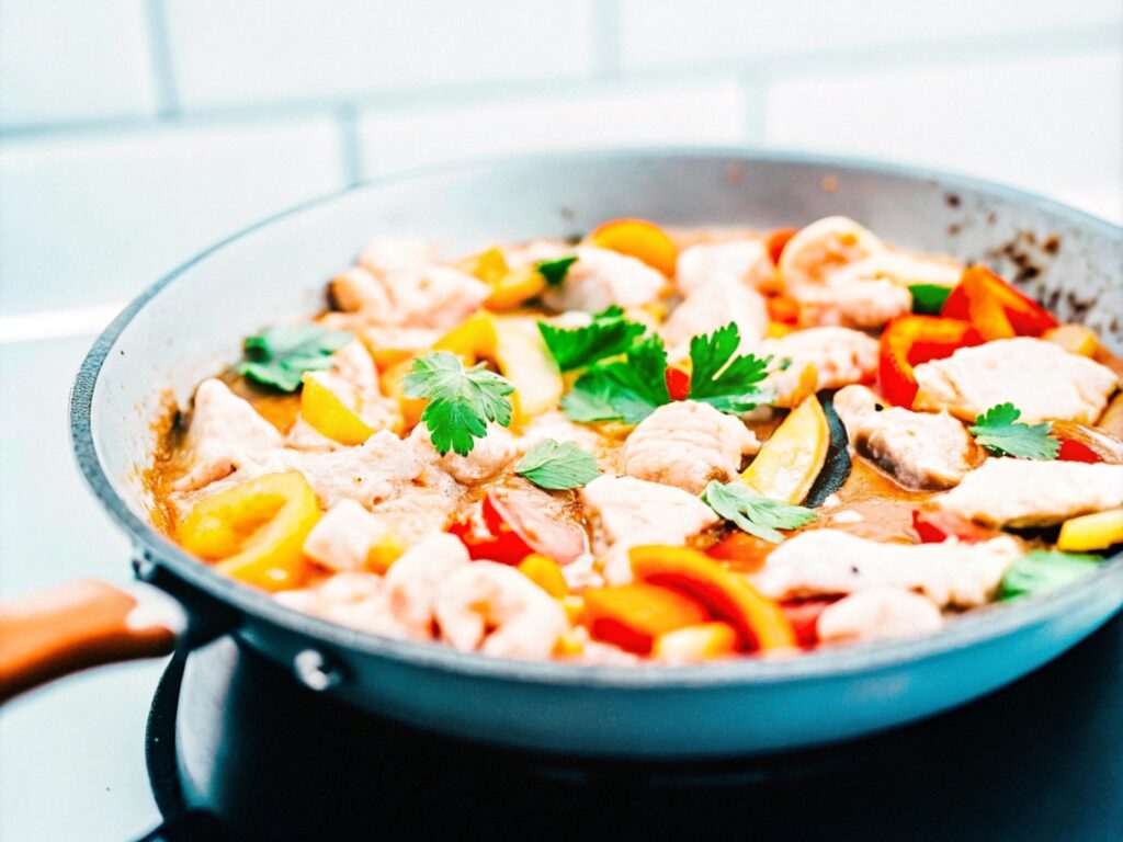 A skillet filled with cooked chicken, shrimp, and sautéed vegetables in a savory sauce, garnished with fresh parsley