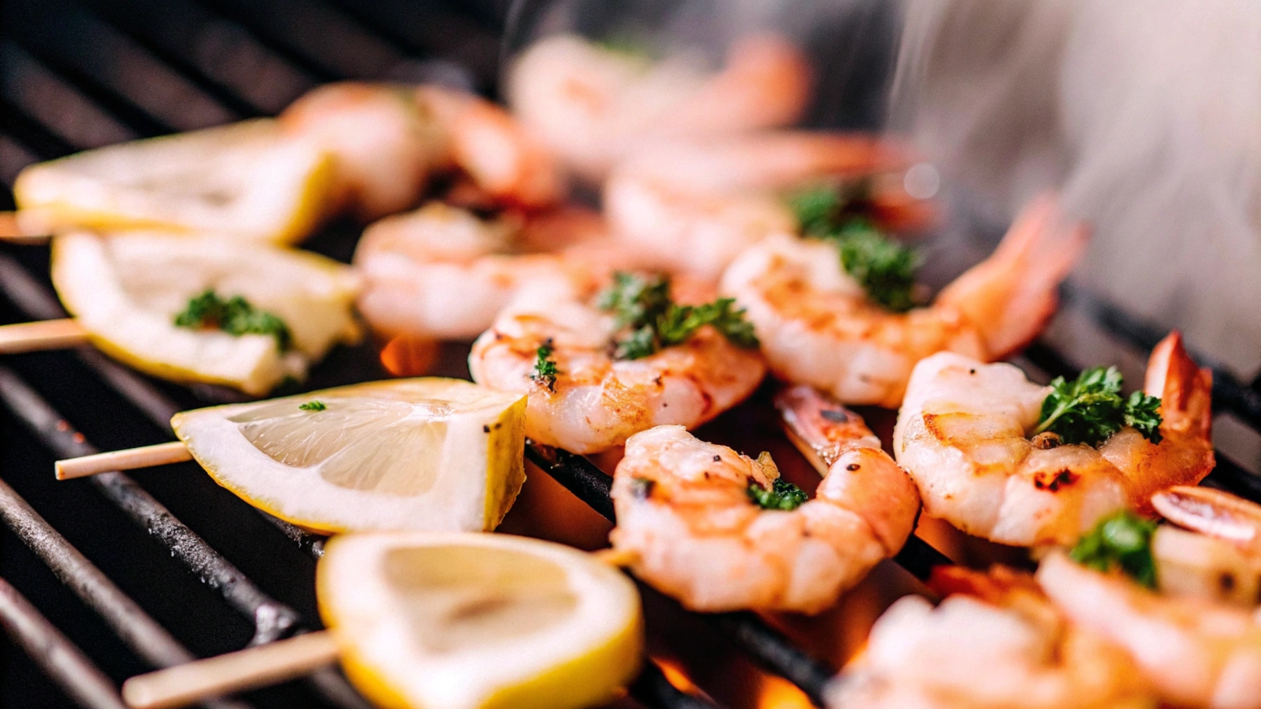 Close-up of grilled shrimp skewers sizzling on a barbecue grill, garnished with fresh parsley and lemon slices.