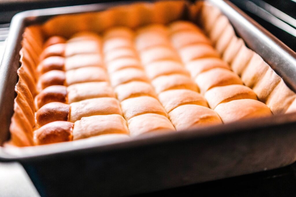 A baking dish lined with crescent roll dough, pressed evenly to form the base layer for the churro cheesecake