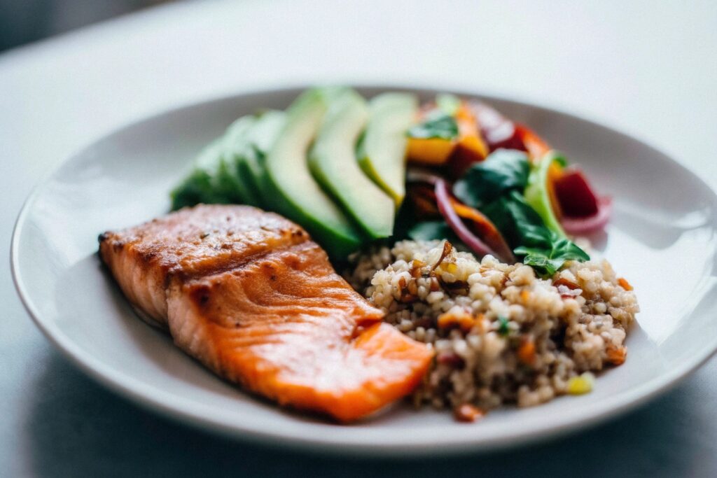 A balanced meal showing salmon alongside quinoa, avocado, and a fresh salad, emphasizing dietary variety