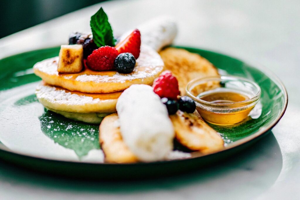 A variety of plated fried banana dishes, including a dessert version with chocolate drizzle, a breakfast option with yogurt, and a savory side with herbs.