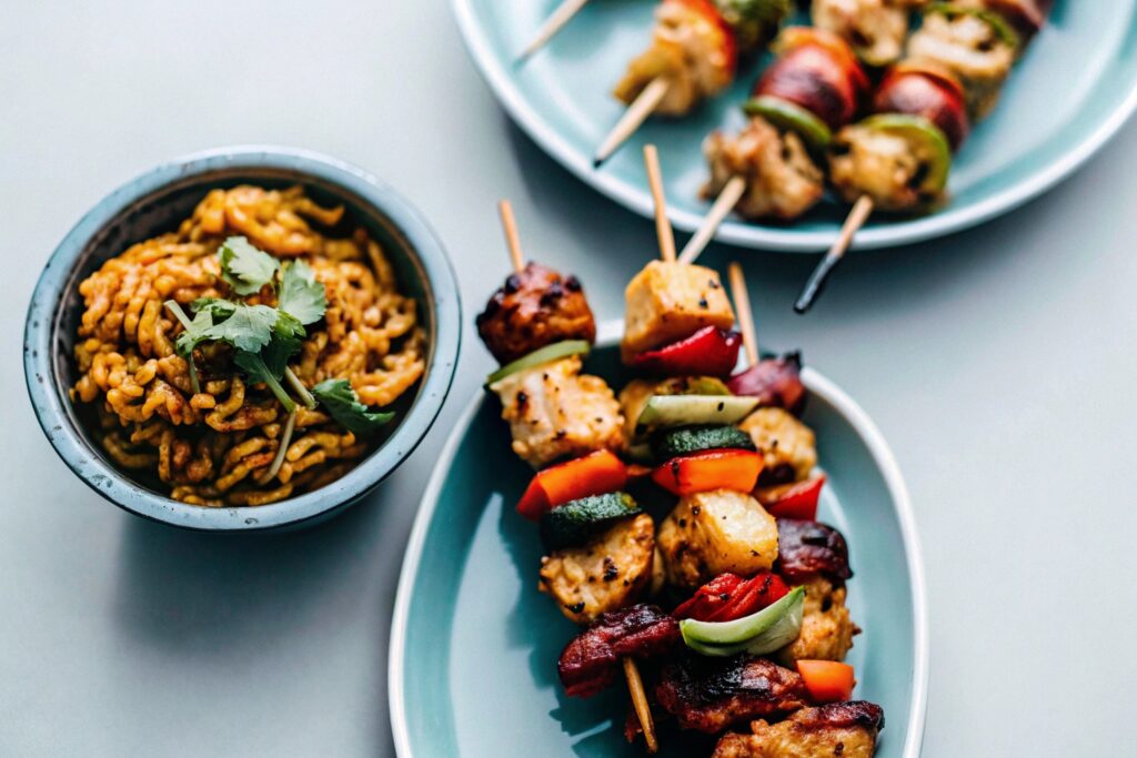 A vibrant assortment of international chicken dishes, featuring skewers, curry, and stir-fry, served on a variety of plates and bowls."