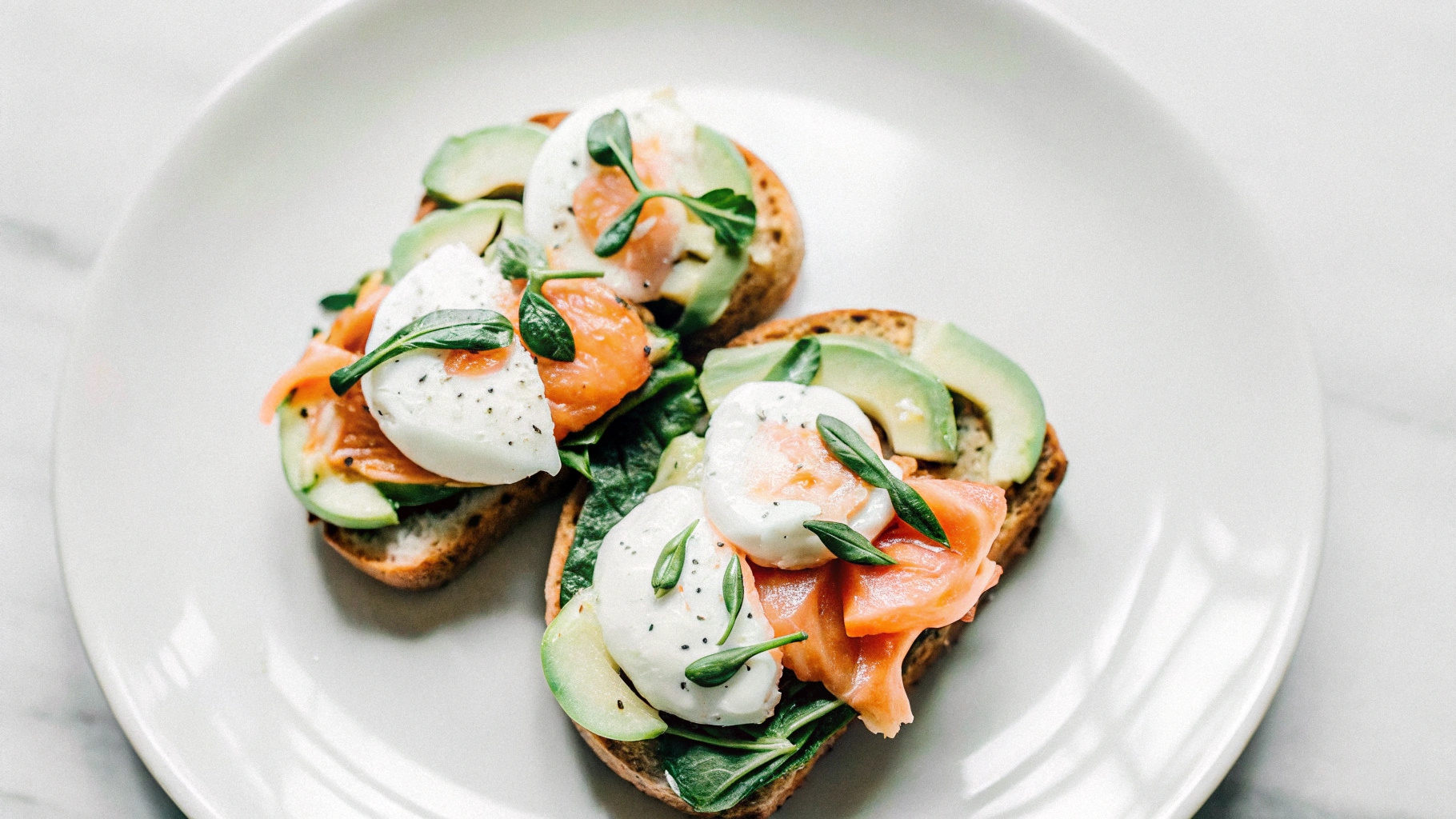 beautifully plated salmon breakfast featuring smoked salmon, avocado slices, and poached eggs on toast