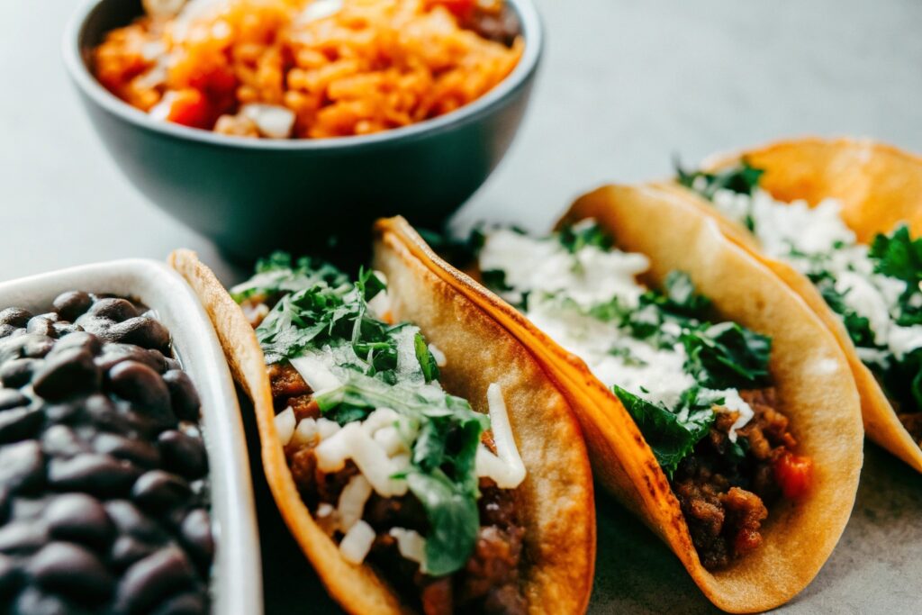 A spread of variations featuring tacos, a bowl with rice, and a vegetarian version with black beans and extra cheese