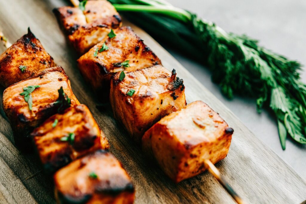 Alt text: Grilled steak cubes with charred edges resting on a wooden cutting board